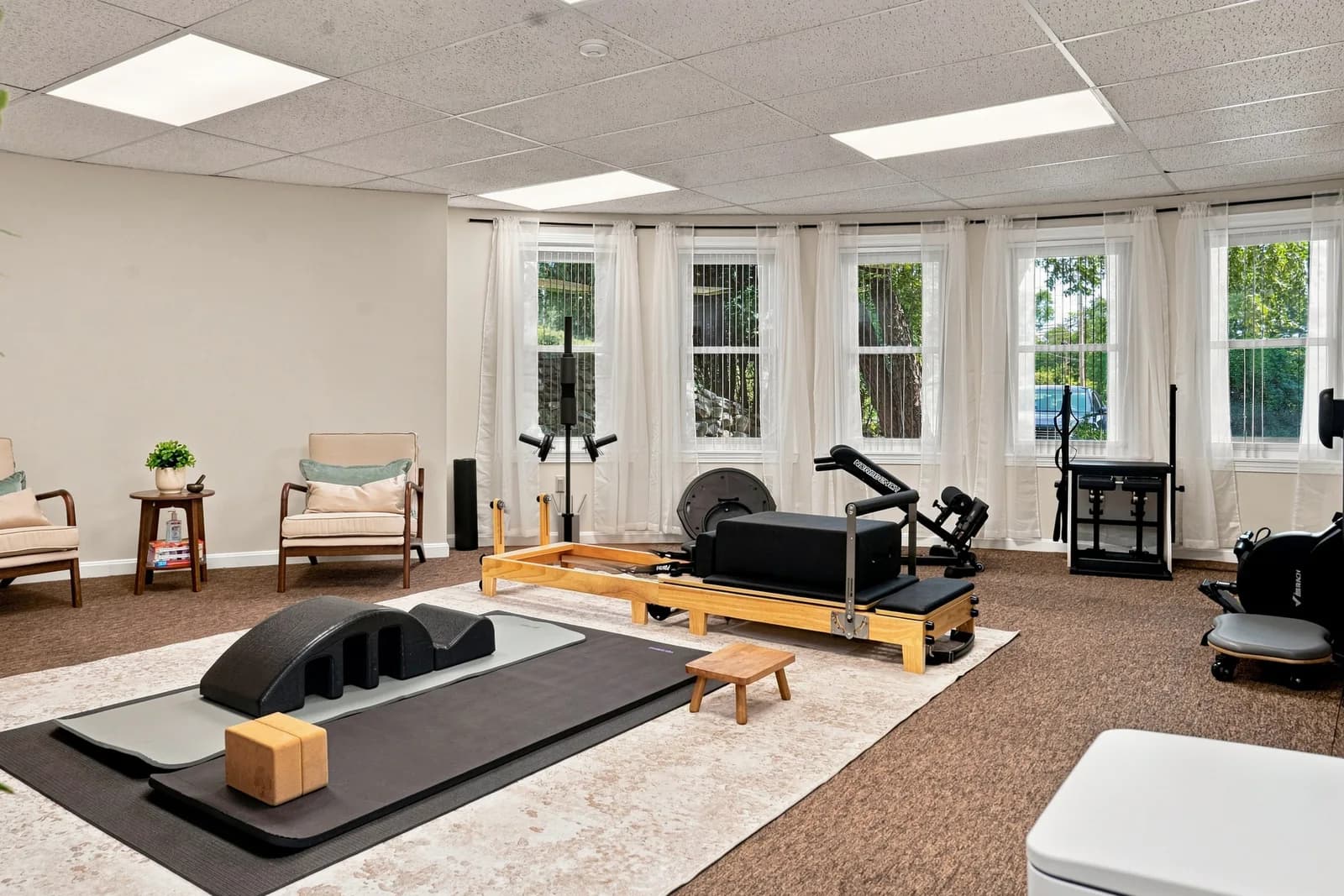 The bright studio at Suubi’s clinic in Harvard, with Pilates equipment and a welcoming seating area. Photography by our team.