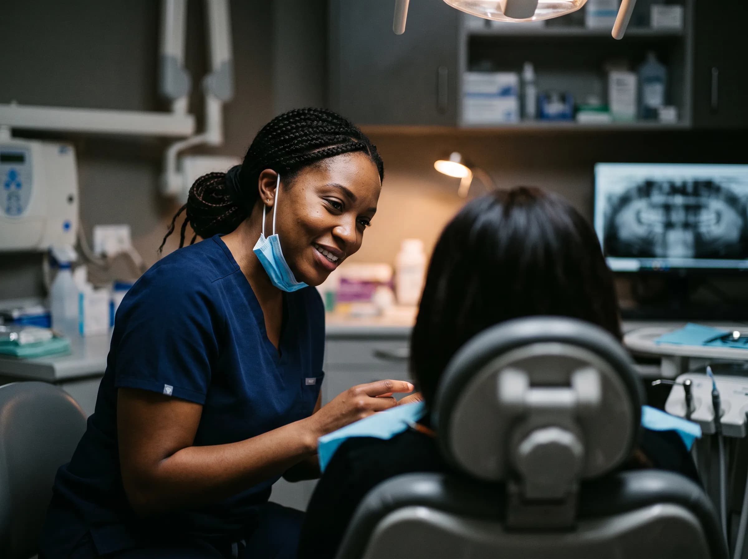 Illustrative candid photo of a dentist talking with a patient in a modern dental operatory, representing the dental practices we build for.